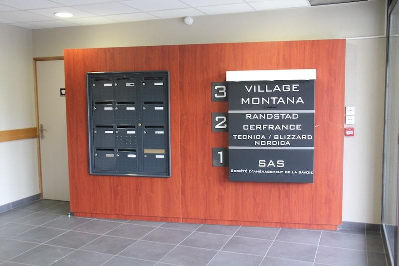 Boîtes aux lettres grises sur un support en bois